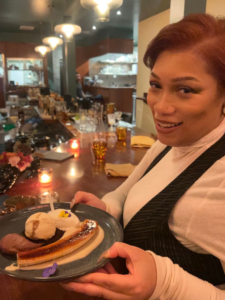 Lena laughs and holds their birthday dessert. 