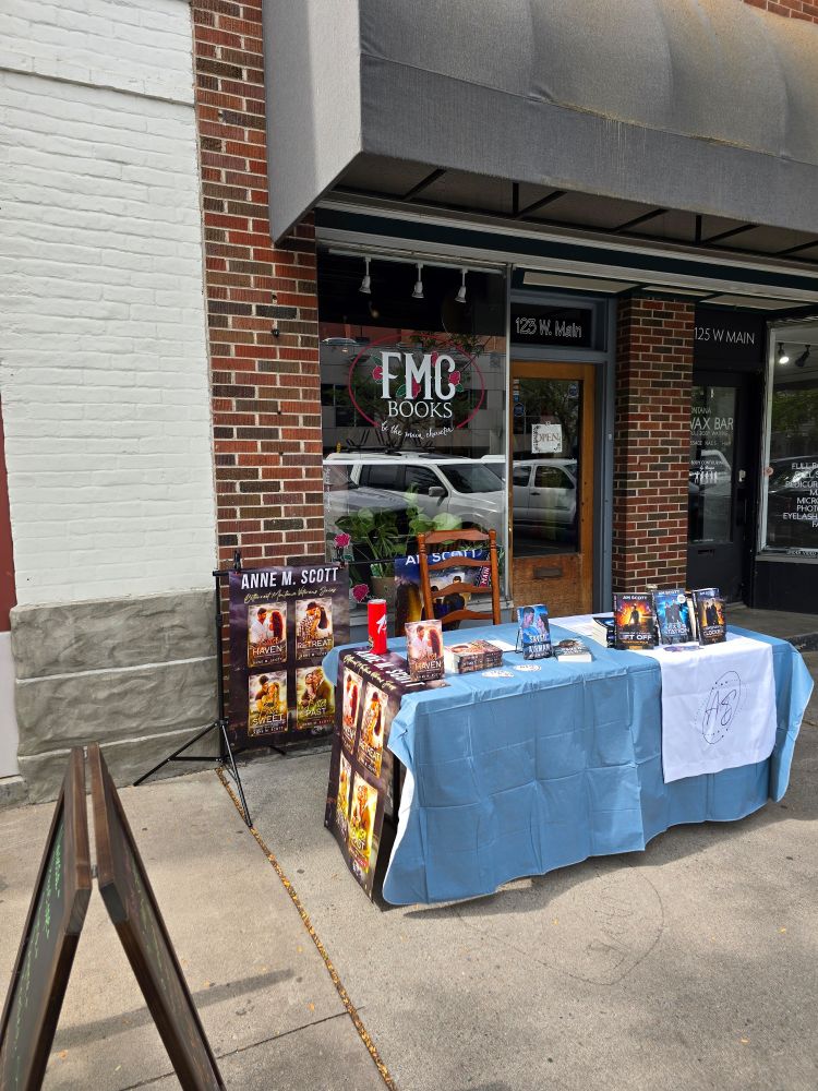 Table with Anne M Scott and AM Scott books set up in front of FMC Books. 