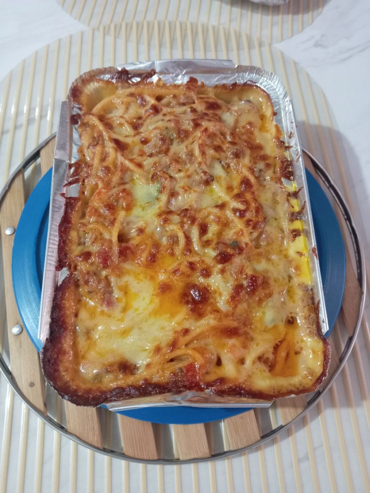 Baked spaghetti in a rectangular aluminum pan.