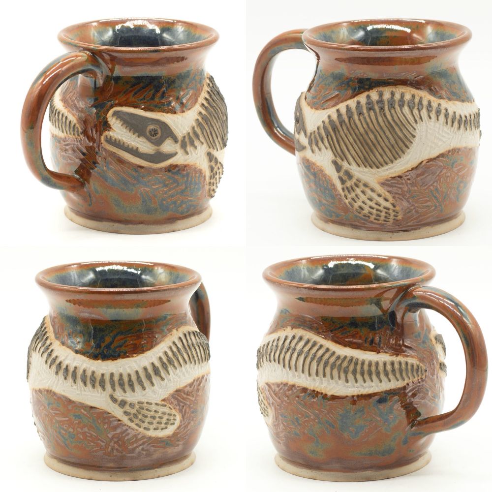 Four views of a ceramic mug decorated with a fossil of a mosasaur 