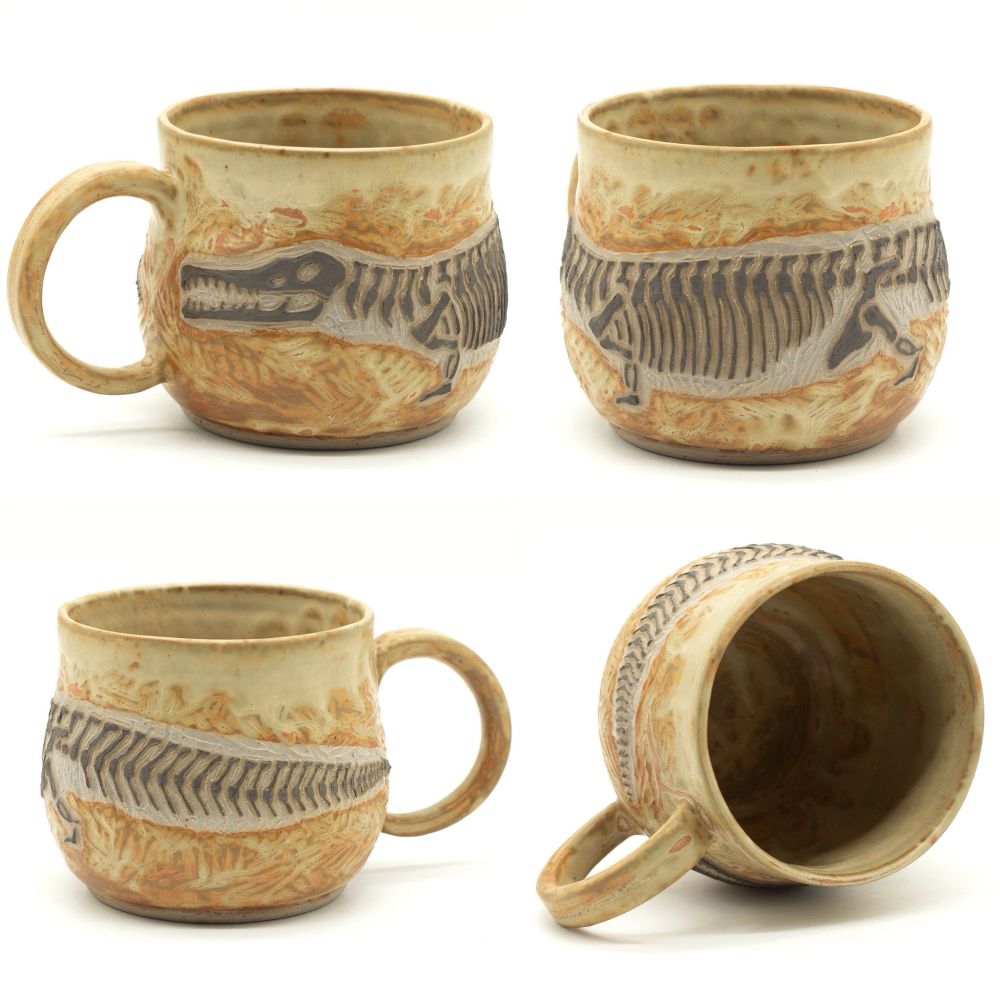 Four views of a ceramic mug decorated with a fossil of a rutiodon