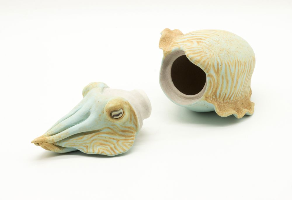 ceramic lidded vessel shaped like a cuttlefish, this time laying on its side with the lid off
