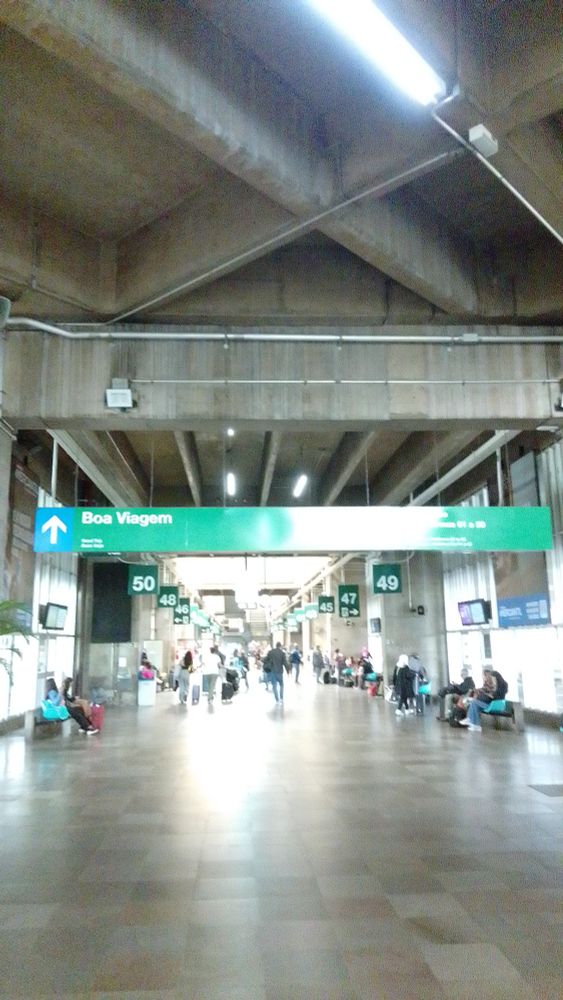 Saguão de acesso às plataformas de embarque, com algumas pessoas sentadas e, ao fundo, algumas em trânsito 