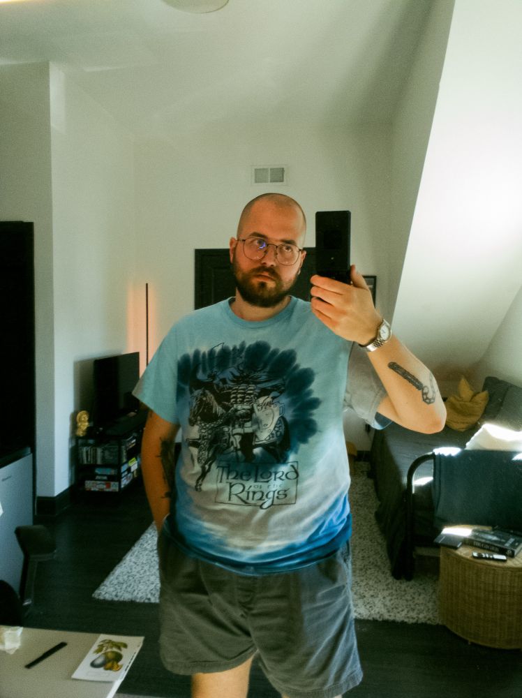 image of a mirror selfie of a bald man with thin-rimmed glasses and a beard. He’s wearing a blue and grey tie dye lord of the rings t shirt with grey shorts.

If you’ve read this far follow me on instagram if you miss my posting on here for whatever reason I’m more active on there recently, @matmcdonut 😌