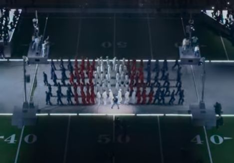 End of superbowl halftime show, dancers are arranged in blue-red-white-red-blue rows, the darkened field makes the colors look more mute, causing it to look like the trans flag