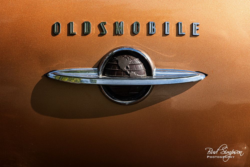 The trunk badge from a 50s era Oldsmobile. It shows the globe encircled by a ring.