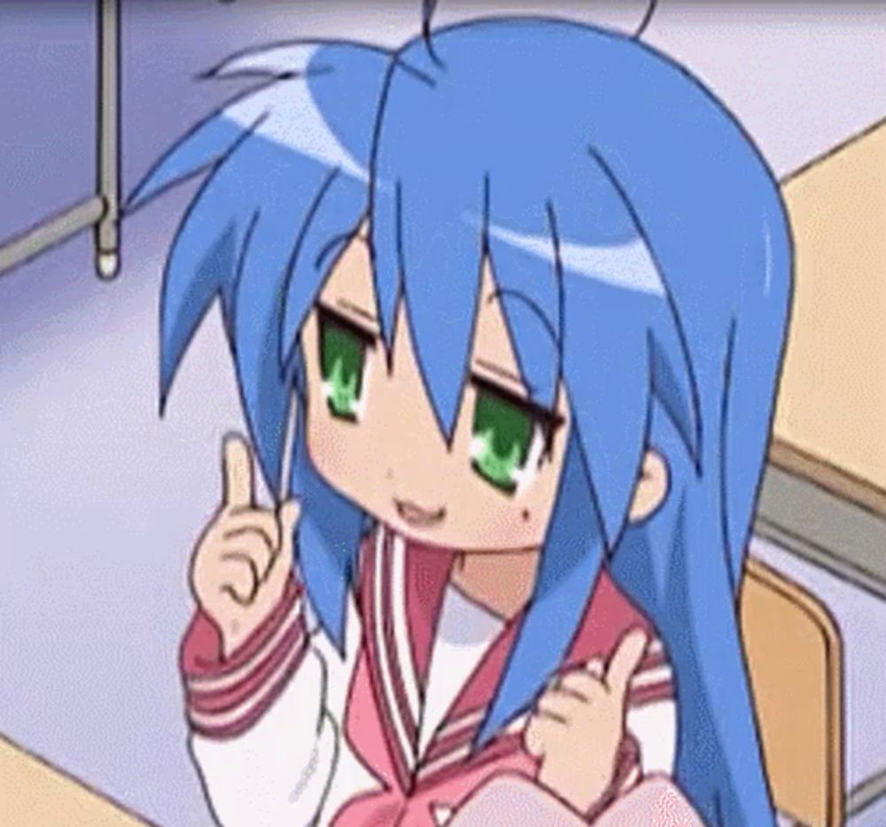 a girl with blue hair and green eyes is sitting at a desk giving a thumbs up .