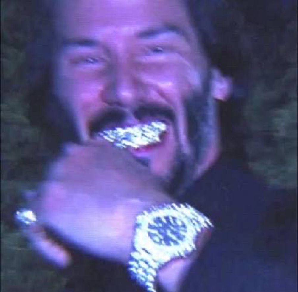 keanu reeves blurry photo with a grill and a diamond watch