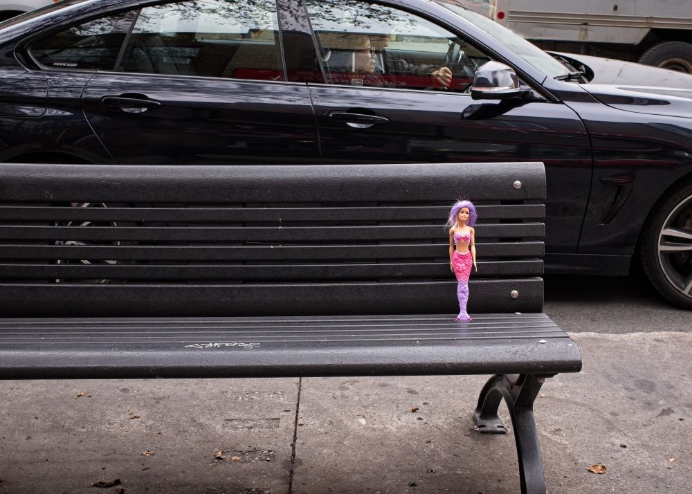 A Barbie doll has been placed standing on a city bench, with the hope that its owner might return. 