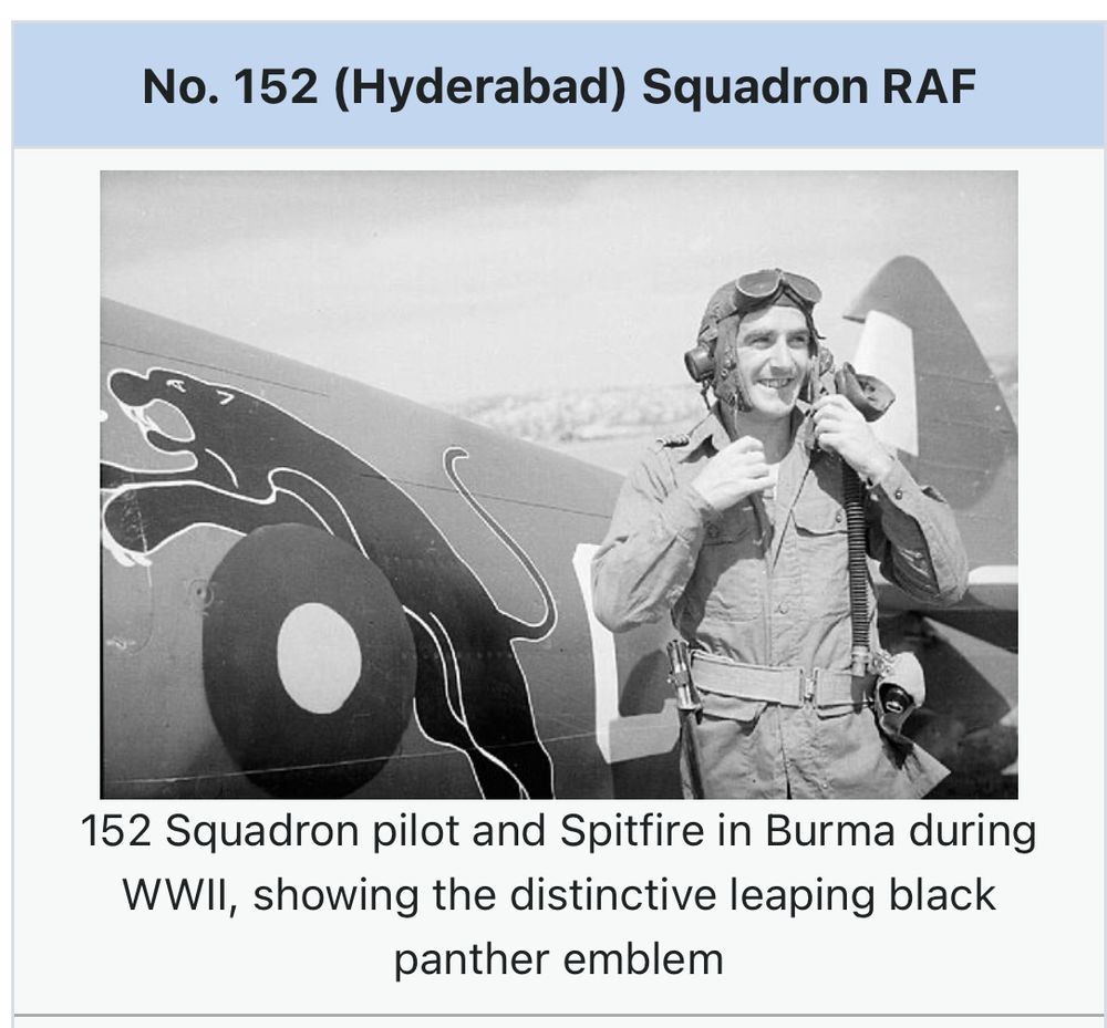 A pilot stands in front of a 152 Squadron Spitfire in Burma. The aircraft has a leaping black Jaguar painted above the roundel on the rear fuselage. 