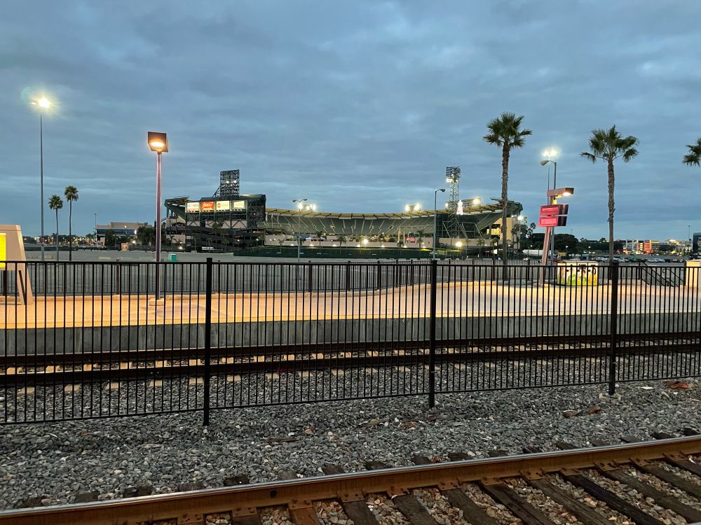 Train tracks and a just before sunrise angel stadium
