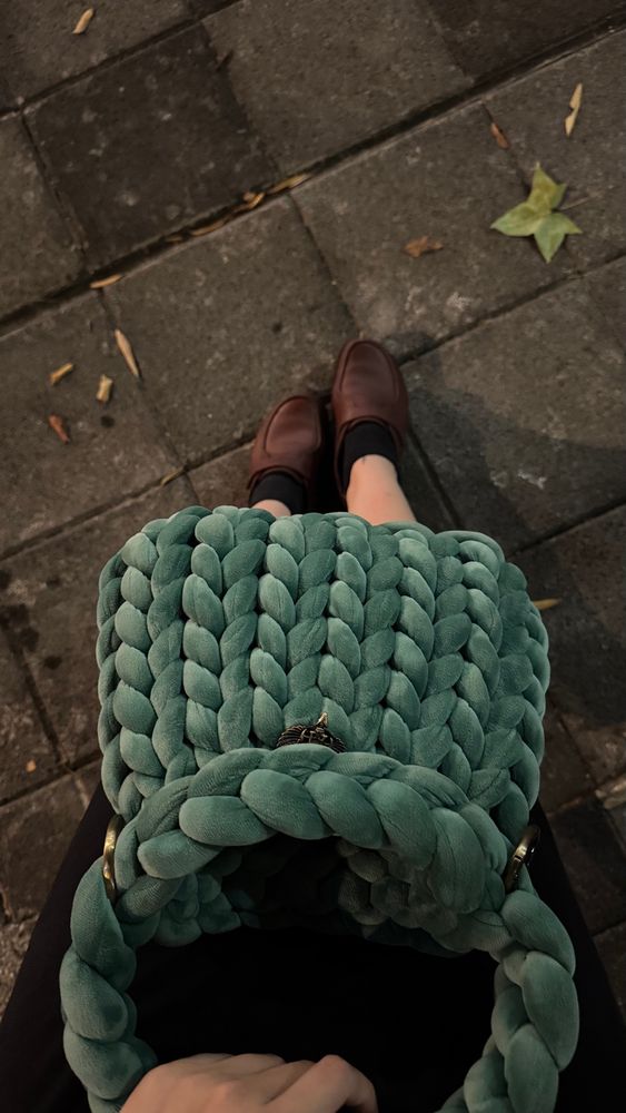 A hand knit, green chunky yarn bag. 