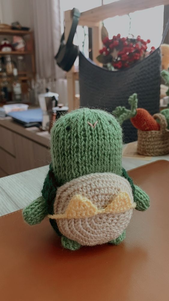 A crochet turtle wearing a bright yellow bikini. 