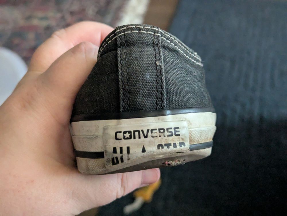 The heel of a black Converse All-Star shoe. The heel originally had the word "All-Star" on the back edge, but the heel is so worn away that only the top third of the word "Star" remains. These shoes were at least 10-15 years old.