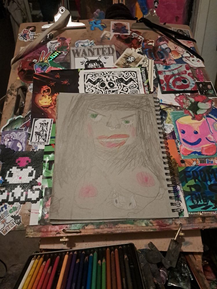 A woman with black hair, green eyes, and red lips with both boobs out and a hello kitty tat in-between both boobs