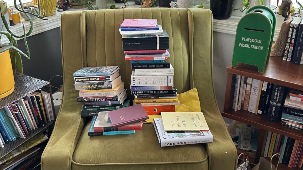 A green armchair piled high with books