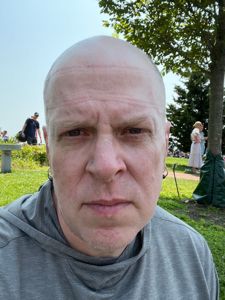 A bald sweaty man appears to be on the verge of tears