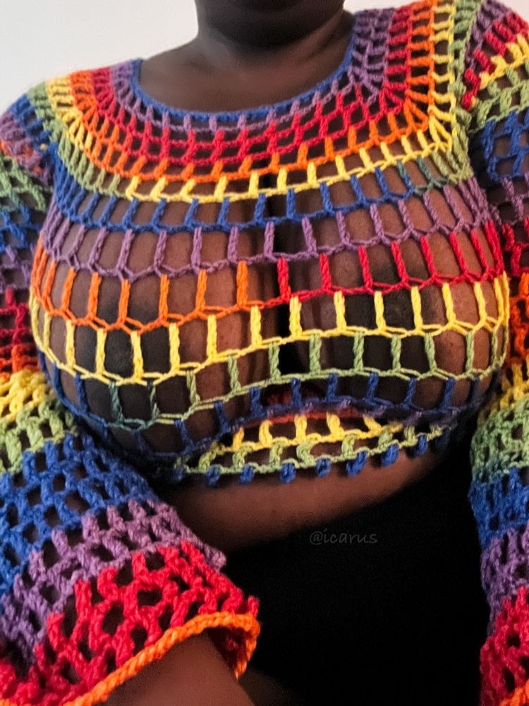 Photo of me wearing a rainbow mesh long-sleeve crop top that I crocheted.