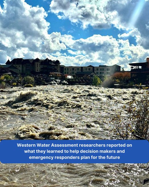 A turbulent brown river floods a downtown area of a small town.