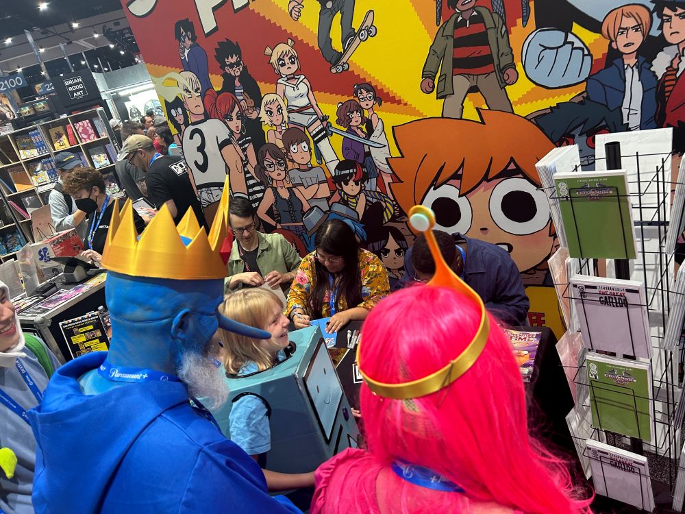 A family dressed as BMO, Ice King, and Princess Bubblehum attend an Adventure Time signing with Nick Winn, Maria Wild, and Patrick Horvath.