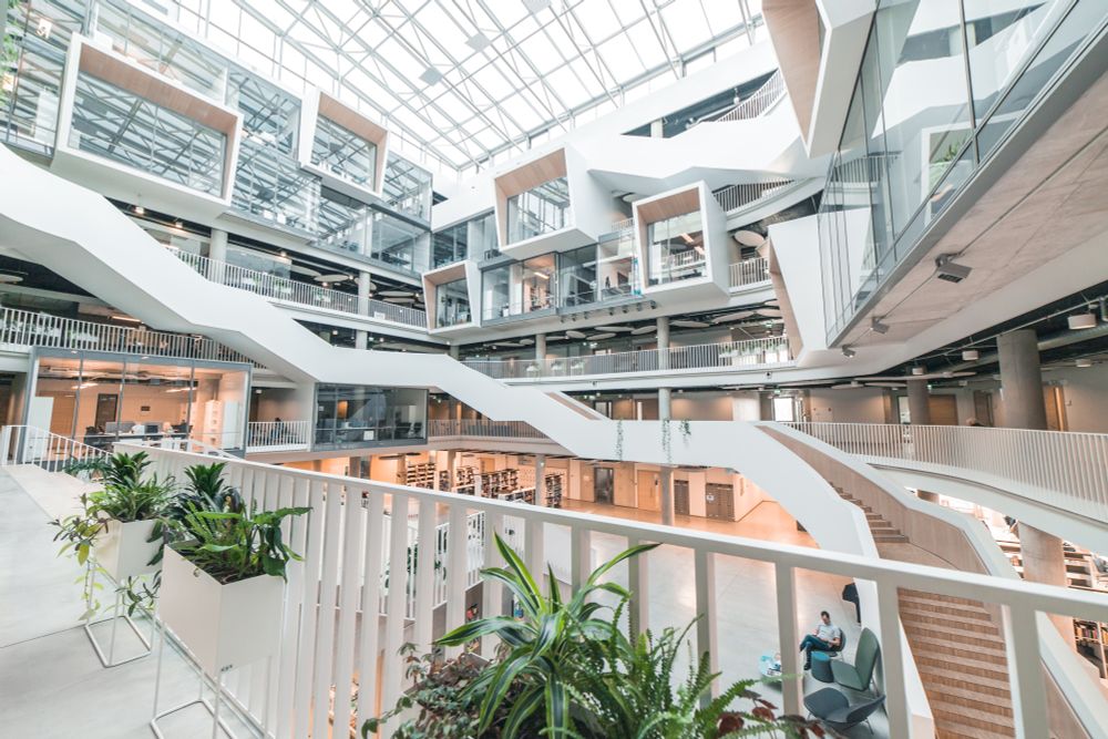 Interior of the University of Latvia’s new campus – open design with multiple glass-front rooms, white staircases, and green plants.
Photo: Toms Grīnbergs, LU