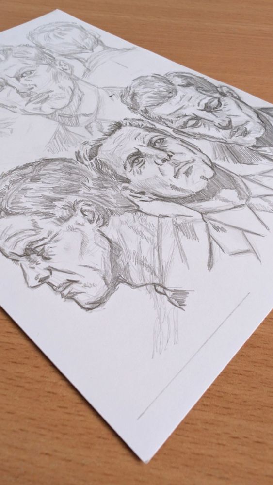 Multiple pencil sketches of President John F. Kennedy's face from several angles on white paper.