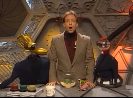 The human test subject Joel and his two robot buddies, Crow and Tom Servo, wear stylish turtlenecks and blazers in a host segment from the MST3K episode Stranded in Space