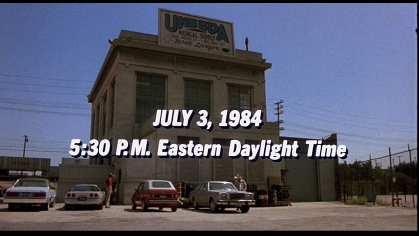 An external shot of the Uneeda Medical Supply building in The Return of the Living Dead.

Text over image: "JULY 3, 1984 - 5:30 P.M. Eastern Daylight Time"