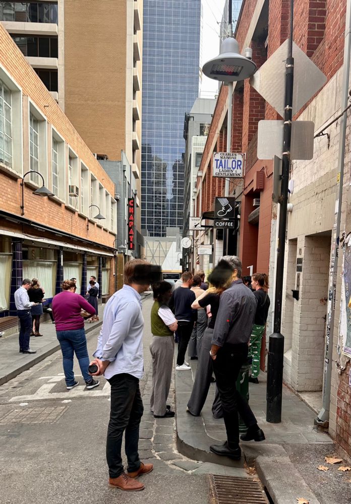People line up for coffee in an alley 
