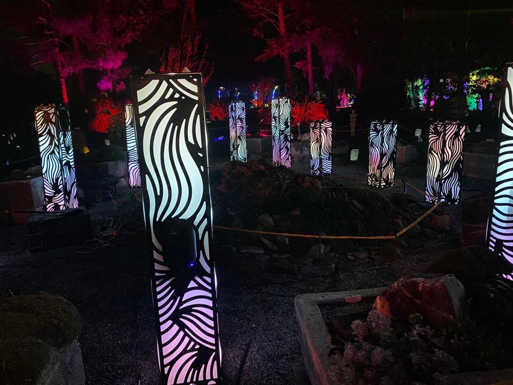 A ring of a dozen speakers mounted in tall rectangular lanterns colored white and blue. 