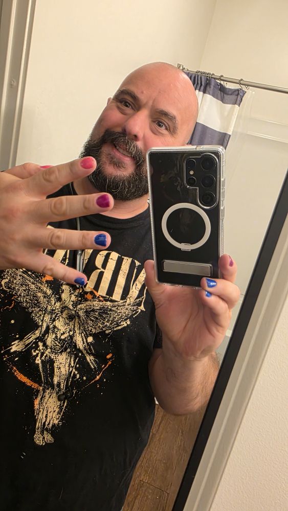 Nick in a nirvana shortshowsnoff his bi pride themed nails.