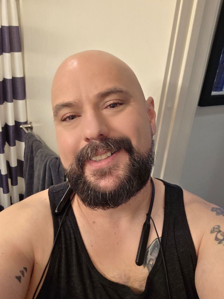 Nick in a black tank smiles at the camera.