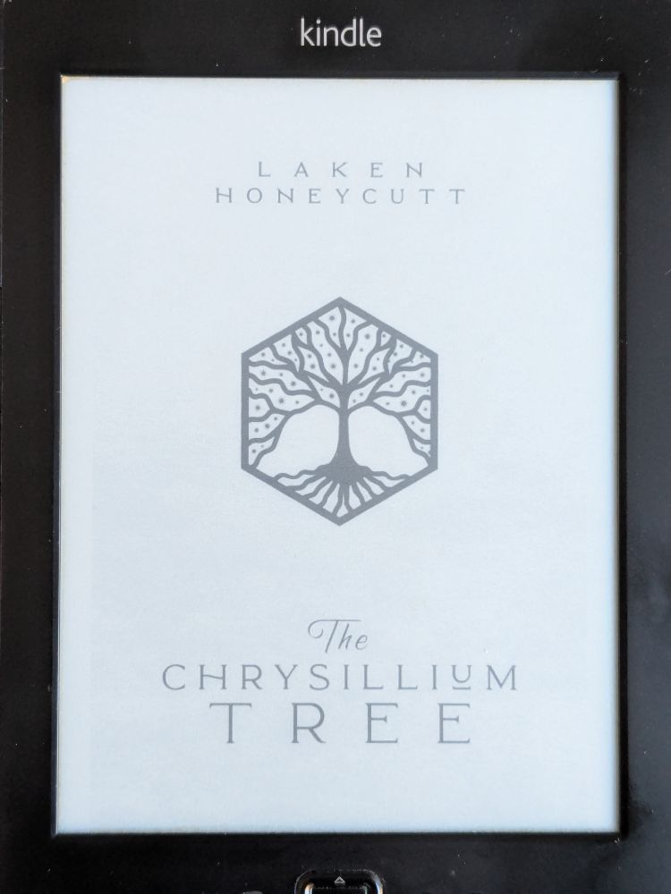 Kindle ebook cover of 'The Chrysillium Tree' by Laken Honeycutt featuring a stylised tree inside a hexagon on a white background.