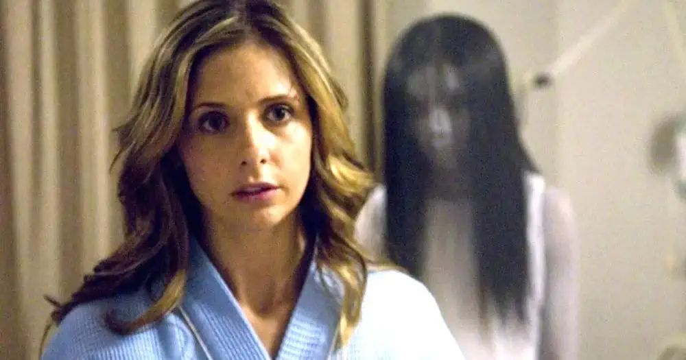 Still scene from 'The Grudge' (2004) with Sarah Michelle Gellar as Karen Davis in the foreground and Takako Fuji as Kayako Saki in the background.