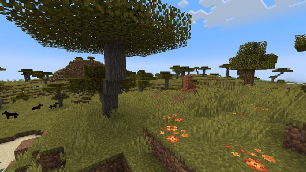 A Minecraft scene in a savannah with orange flowerbeds, termite mounds, and horses at the background. The orange and yellow colored flowerbed is called "Lantana."