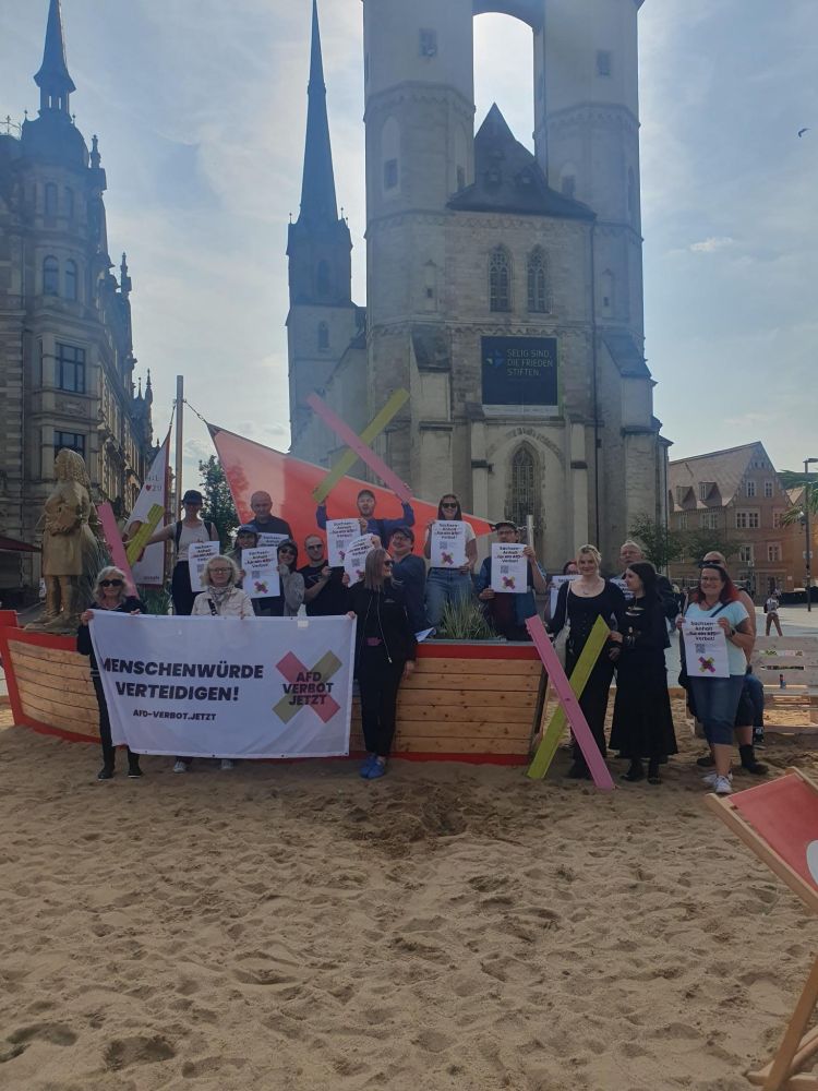 Ca. 20 Pers. mit AfD-Verbots-Trasparent auf dem Marktplatz in Halle.