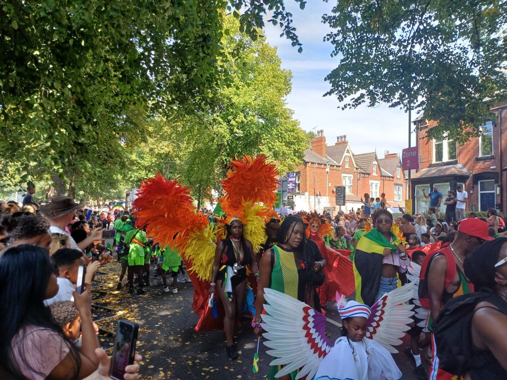 A carnival dance troupe in bright loud feathered costume 