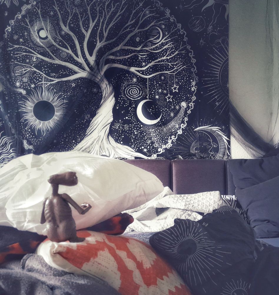 E.T. auf einer kissenburg im Bett, er bezieht das Bett frisch 