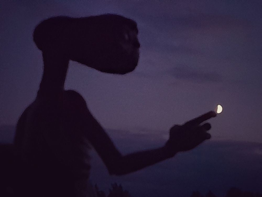 E.T. tippt mit dem Zeigefinger den vollwerdenden Mond an