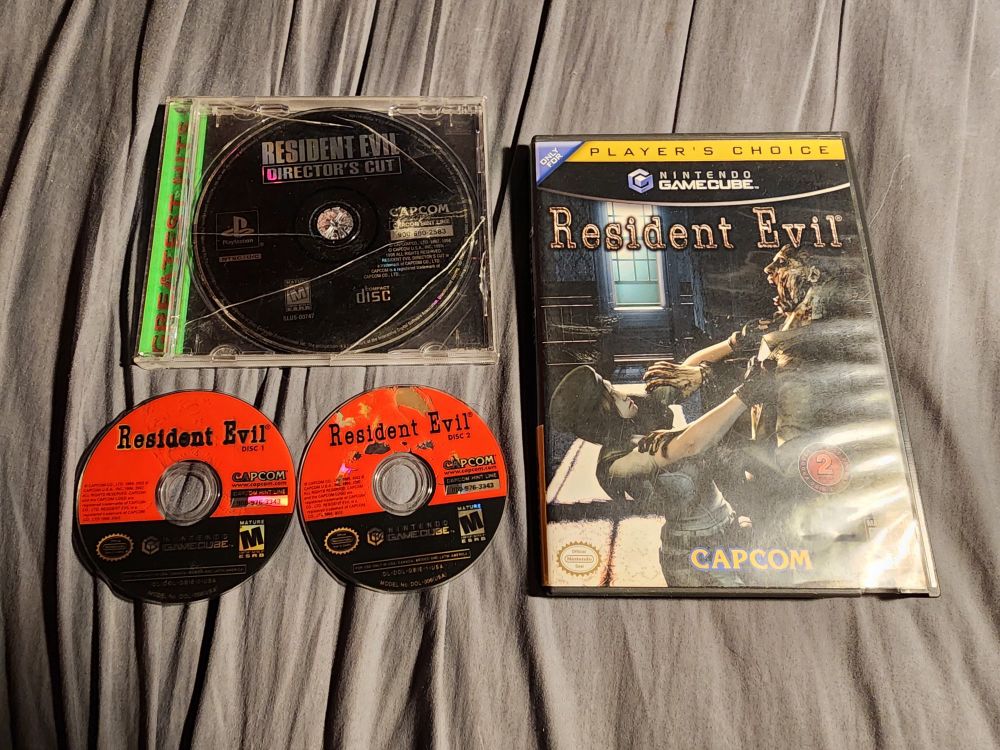 Resident Evil Remake on Gamecube's case, discs, and also a pretty beat up but still hanging on copy of Resident Evil Director's Cut on PS1.