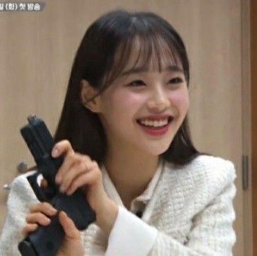 chuu smiling with a gun 