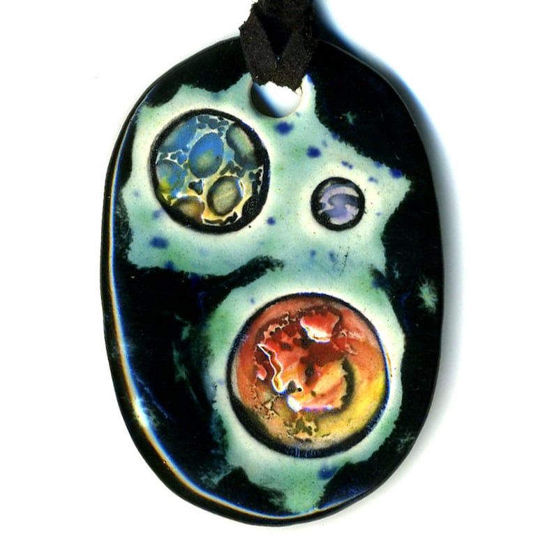 A ceramic pendant with 3 planets. 