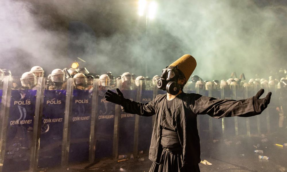 A protester wearing a whirling dervish costume performs in front of Turkish riot police barricades during a protest in Istanbul against the detention of its mayor, Ekrem İmamoğlu. Photograph: Erdem Şahin/EPA