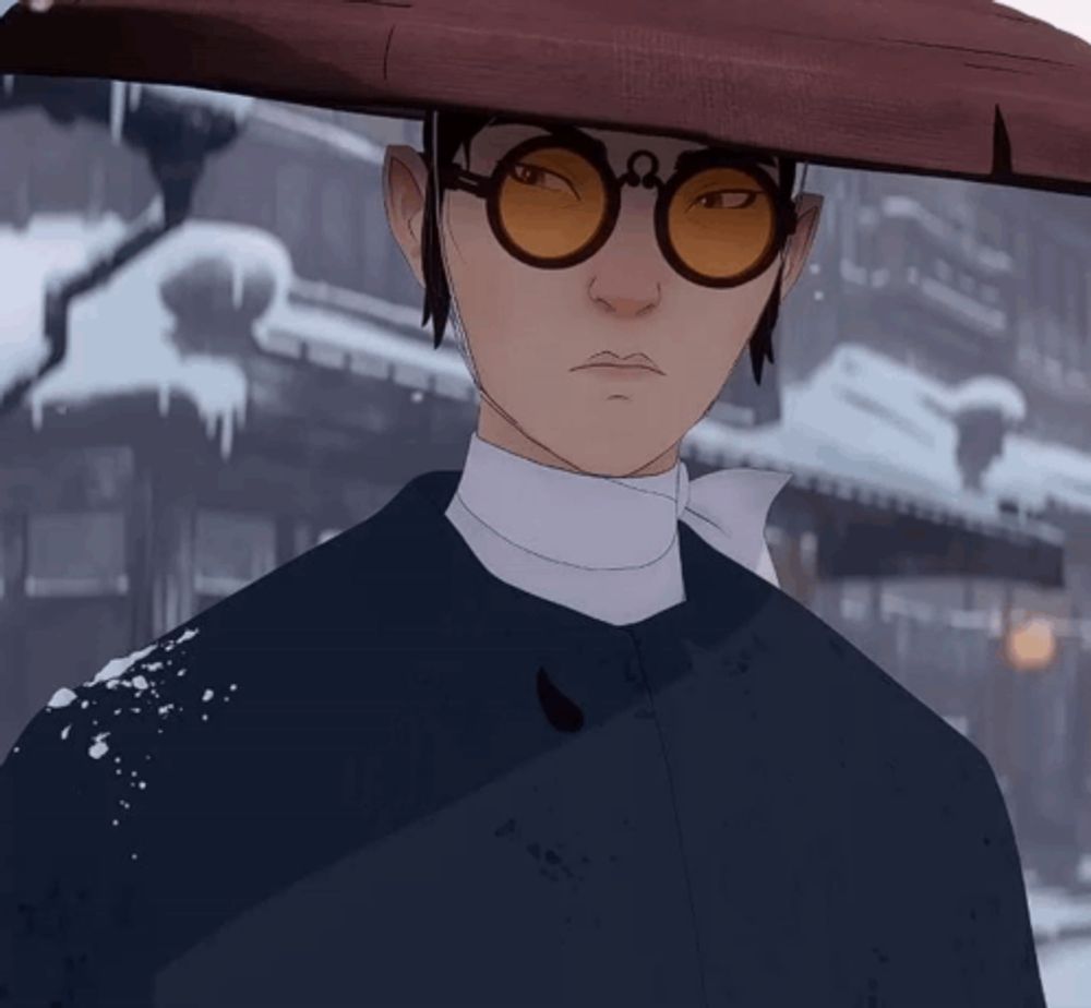 a man wearing glasses and a hat is standing in the snow looking at the camera