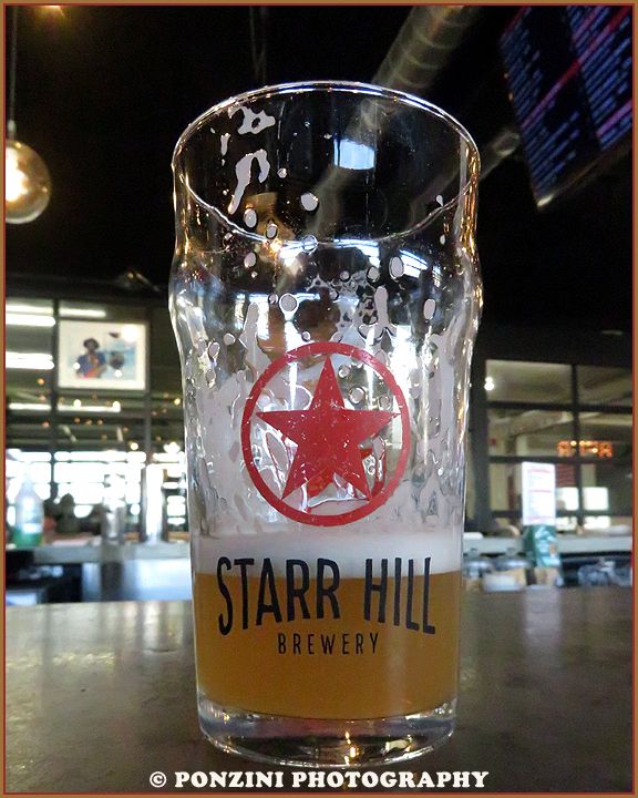 An almost empty glass of a Frootie & The Blowfish Sour sits on the bar at Starr Hill Brewery.