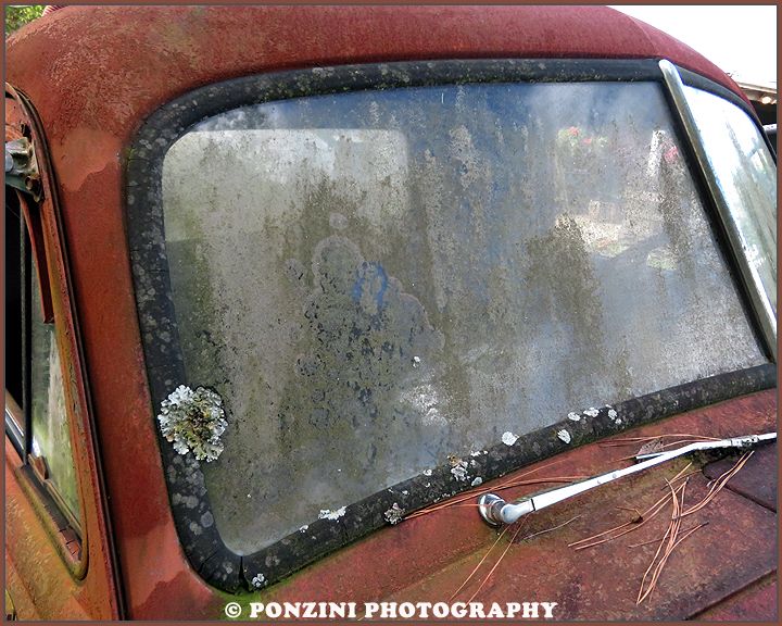 The grimy windshield of a vintage Chevy Tanker truck.