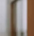 a blurry picture of a door with a white handle and a brown door .