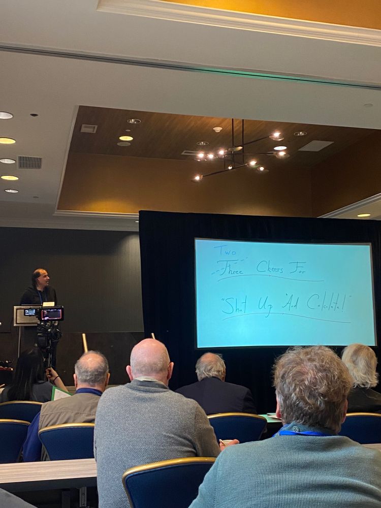Nima Arkani-Hamed, the theoretical physicist, presents a slide that says “Two cheers for shut up and calculate”