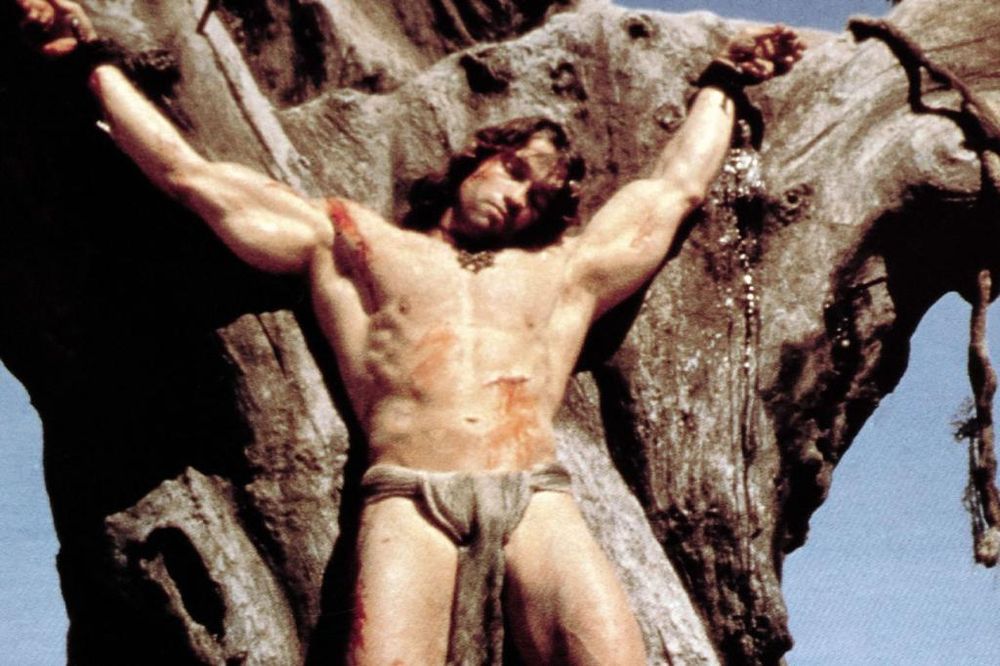 Arnold Schwarzenegger nailed to a tree in Conan The Barbarian (1982).