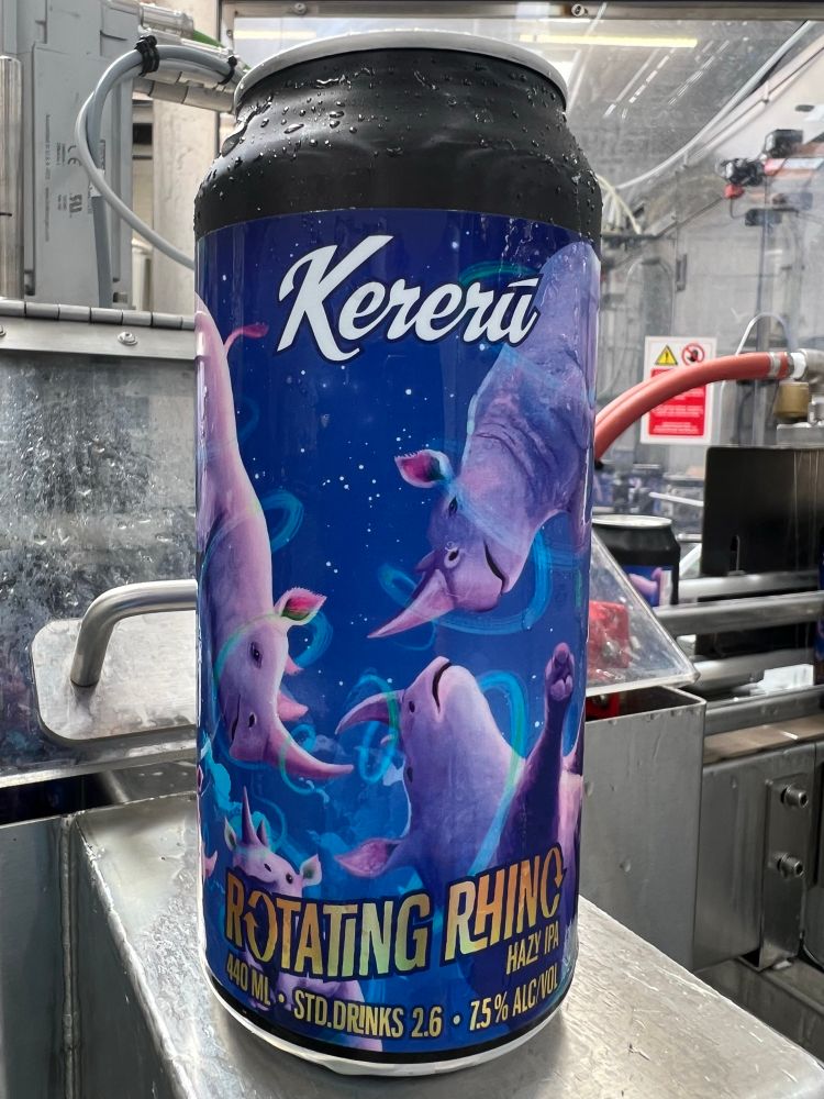 A can of  Kererū Rotating Rhino Hazy IPA is shown, freshly filled and covered in condensation. The label features many rhinos in a variety of weightless floaty rotating poses.